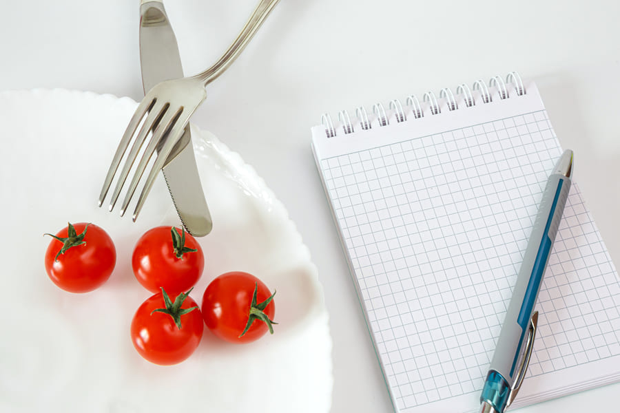 cherry-tomatoes-plate-with-cutlery-notebook-recording-counting-calories-diet-food (1).jpeg