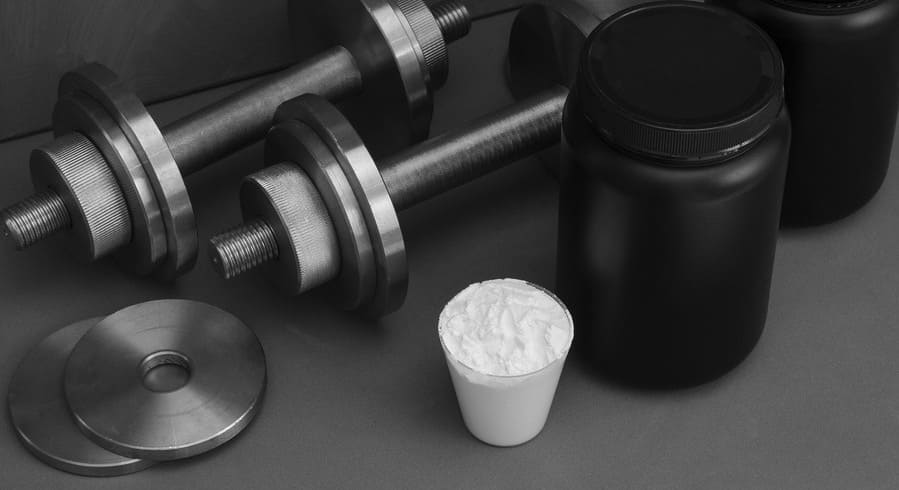 sports-nutrition-with-dumbbells-gray-surface (1).jpeg