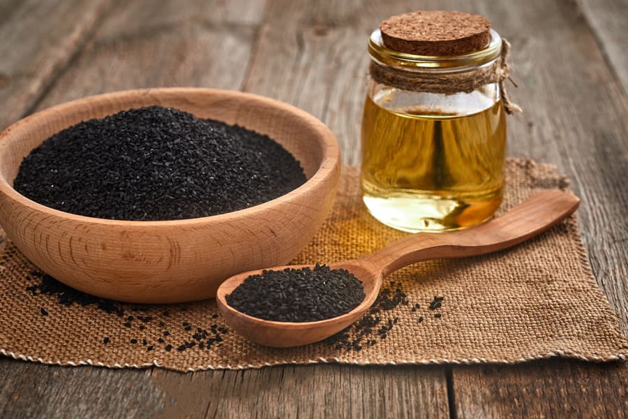 black-cumin-seeds-wooden-spoon-bowl-with-bottle-oil-wooden-table (1).jpeg