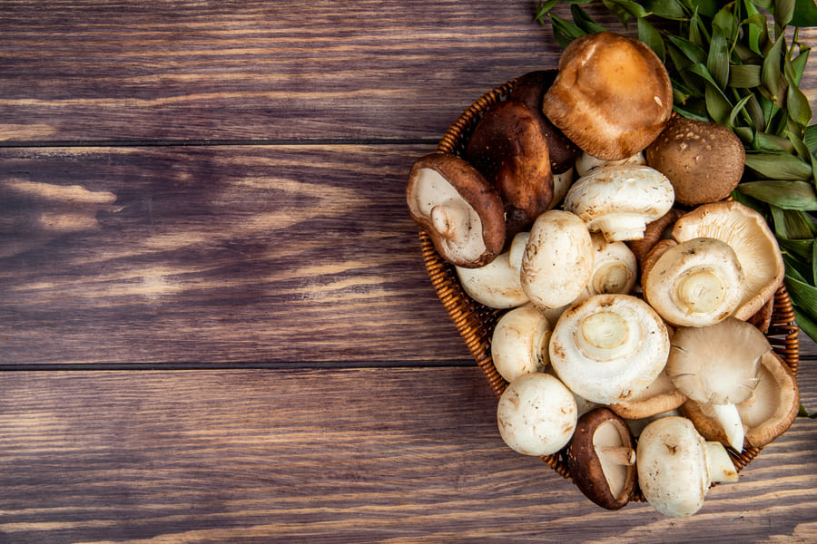 top-view-fresh-mushrooms-wicker-basket-rustic-wood-with-copy-space (1).jpeg
