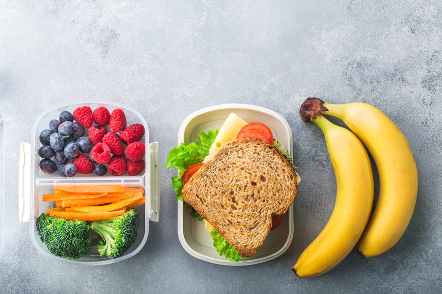 school-lunch-box-with-sandwich-vegetables-berries-banana-grey-table-healthy (1).jpeg