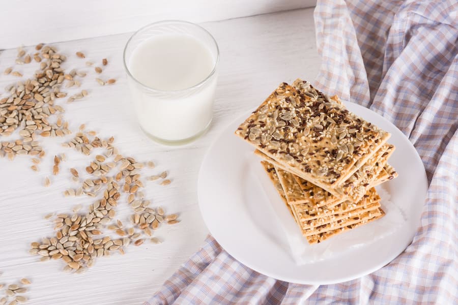 stack-crispy-wheat-cakes-with-sesame-flax-sunflower-seeds-napkin-white-wooden-background-with-glass-milk (1).jpeg