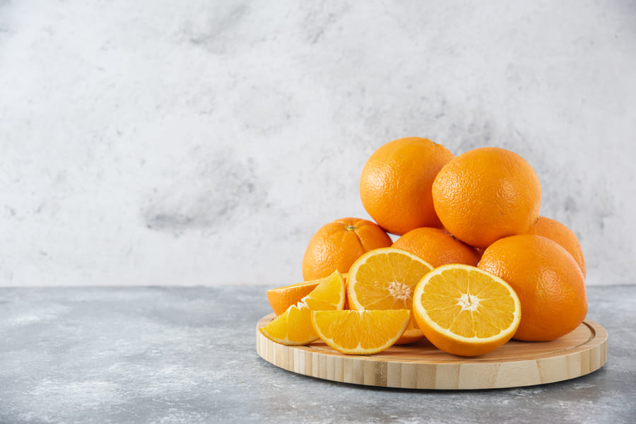 wooden-board-full-juicy-slices-orange-fruit-stone-table (1).jpeg