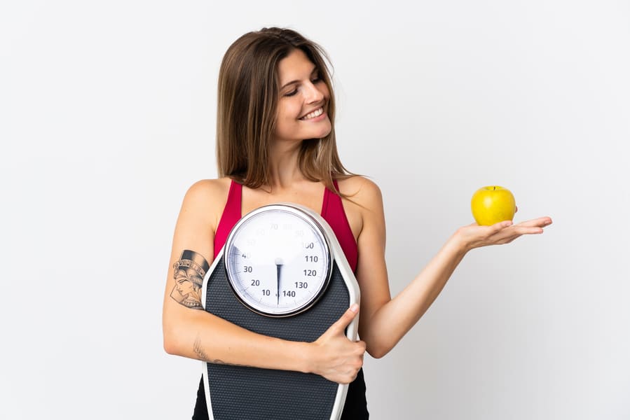 young-slovak-woman-isolated-white-holding-weighing-machine-while-looking-apple (1).jpeg
