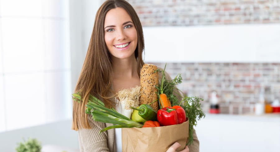 beautiful-young-woman-with-vegetables-grocery-bag-home.jpeg