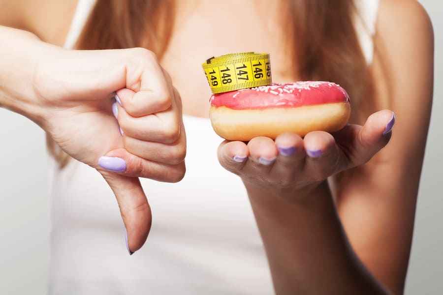diet-donut-no-young-girl-holds-donut-her-hand-shows-her-finger-bottom-no-sweet-macrophotocrats-concept-health-gray-background (1).jpeg